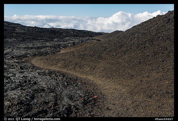 Trail through olivine hill bordering aa lava. Hawaii Volcanoes National Park, Hawaii, USA.