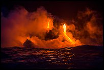 Lava cascades lighting ocean at night. Hawaii Volcanoes National Park, Hawaii, USA.