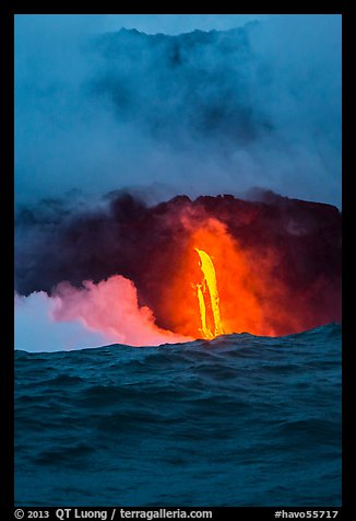 A single spigot of lava creates a large plume steam at sunrise upon reaching ocean. Hawaii Volcanoes National Park, Hawaii, USA.