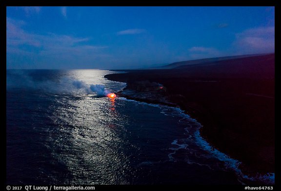 Aerial view of coastline with distant lava ocean entry and moonlight reflections at night. Hawaii Volcanoes National Park (color)