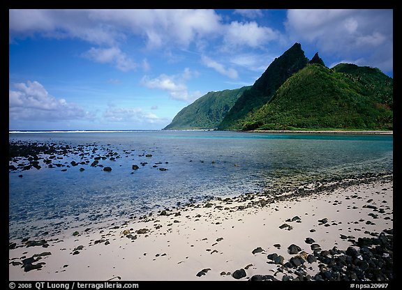 Tropical beach with sand and pebbles, and pointed peaks of Ofu Island. National Park of American Samoa