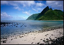 Tropical beach with sand and pebbles, and pointed peaks of Ofu Island. National Park of American Samoa