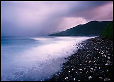 Coastline with dark rocks, light water and storm sky at sunrise, Vatia bay, Tutuila Island. National Park of American Samoa