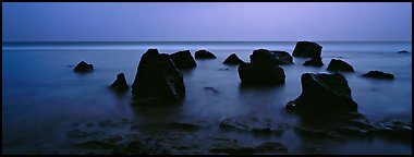 Seascape with boulders in water at dusk. National Park of American Samoa (Panoramic color)