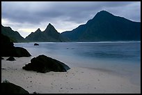 Balsalt boulders on South Beach, Sunuitao Peak and Piumafua mountain on Olosega Island in the background, Ofu Island. National Park of American Samoa