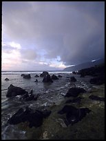 Boulders and coastline at sunrise with rainbow, Siu Point, Tau Island. National Park of American Samoa