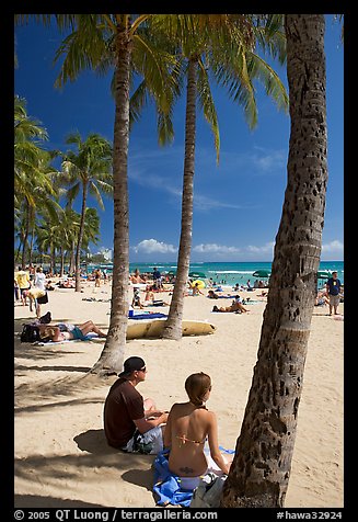 Couple under palm trees on Waikiki beach. Waikiki, Honolulu, Oahu island, Hawaii, USA (color)