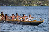 Outrigger canoe paddled by women in bikini, Maunalua Bay, late afternoon. Oahu island, Hawaii, USA (color)