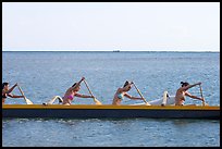 Side view of women in bikini paddling a outrigger canoe, Maunalua Bay, late afternoon. Oahu island, Hawaii, USA (color)