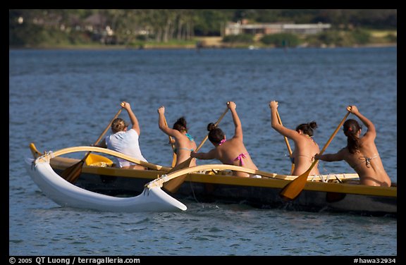 Back view of women in bikini paddling a outrigger canoe, Maunalua Bay, late afternoon. Oahu island, Hawaii, USA