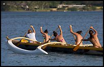 Back view of women in bikini paddling a outrigger canoe, Maunalua Bay, late afternoon. Oahu island, Hawaii, USA ( color)