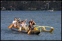 Boys paddling an outrigger canoe, Maunalua Bay, late afternoon. Oahu island, Hawaii, USA (color)