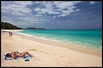 Woman sunning herself on Waimanalo Beach. Oahu island, Hawaii, USA