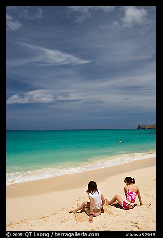 Young women sitting on Waimanalo Beach. Oahu island, Hawaii, USA (color)