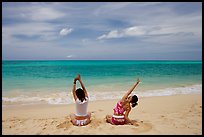 Young women stretching on Waimanalo Beach. Oahu island, Hawaii, USA