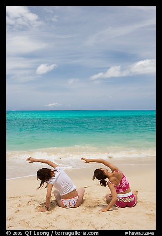 Young women doing gymnastics on Waimanalo Beach. Oahu island, Hawaii, USA (color)