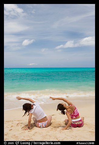 Young women doing gymnastics on Waimanalo Beach. Oahu island, Hawaii, USA