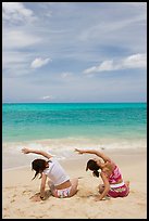 Young women doing gymnastics on Waimanalo Beach. Oahu island, Hawaii, USA (color)