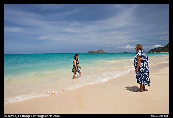 Two women, the Older in hawaiian dress, on Waimanalo Beach. Oahu island, Hawaii, USA