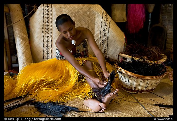 Fiji woman tying together leaves with her feet. Polynesian Cultural Center, Oahu island, Hawaii, USA