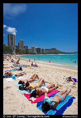 Young women on Waikiki Beach with skyline in the background. Waikiki, Honolulu, Oahu island, Hawaii, USA