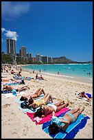 Young women on Waikiki Beach with skyline in the background. Waikiki, Honolulu, Oahu island, Hawaii, USA (color)