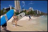 Women carrying surfboards into the water, Waikiki Beach. Waikiki, Honolulu, Oahu island, Hawaii, USA (color)