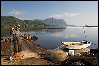 Fisherman pulling out net out of small baot, Kaneohe Bay, morning. Oahu island, Hawaii, USA