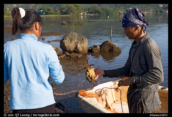 Fisherman giving a freshly caught crab to his wife, Kaneohe Bay, morning. Oahu island, Hawaii, USA (color)