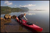 Man loading sea kayak for a fishing trip, Kaneohe Bay, morning. Oahu island, Hawaii, USA (color)