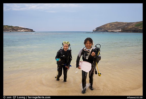 Scuba divers walking out of the water, Hanauma Bay. Oahu island, Hawaii, USA