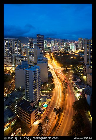 Boulevard and high rise buildings at dusk. Waikiki, Honolulu, Oahu island, Hawaii, USA