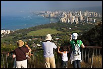 Tourists look at Waikidi from the  Diamond Head crater, early morning. Oahu island, Hawaii, USA