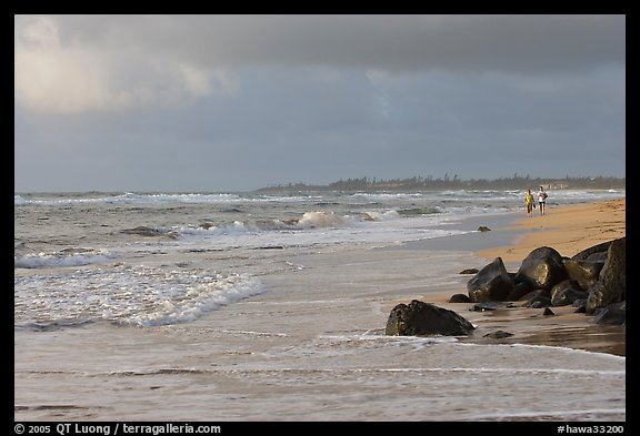 Couple strolling on the beach, Lydgate Park, early morning. Kauai island, Hawaii, USA (color)