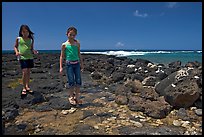 Girls playing in tidepool, Kukuila. Kauai island, Hawaii, USA