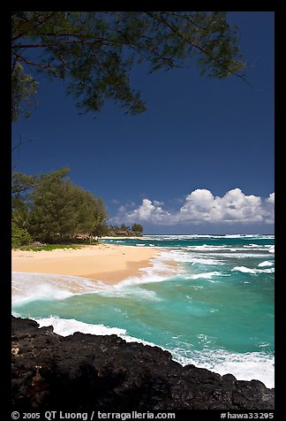 Beach, volcanic rock, and turquoise waters, and homes  near Haena. North shore, Kauai island, Hawaii, USA