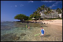 Children on Puu Poa Beach and Princeville Hotel. Kauai island, Hawaii, USA (color)