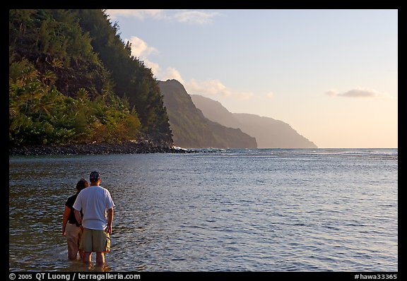 Couple standing in water, Kee Beach, late afternoon. Kauai island, Hawaii, USA