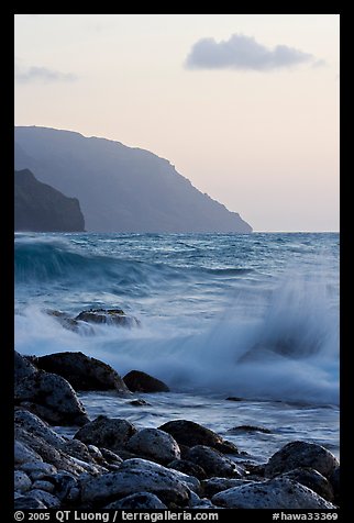 Boulders, waves, and Na Pali cliffs, sunset. Kauai island, Hawaii, USA (color)