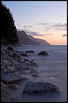 Boulders, surf, and Na Pali Coast, sunset. Kauai island, Hawaii, USA