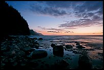 Boulders, surf, and Na Pali Coast, dusk. Kauai island, Hawaii, USA