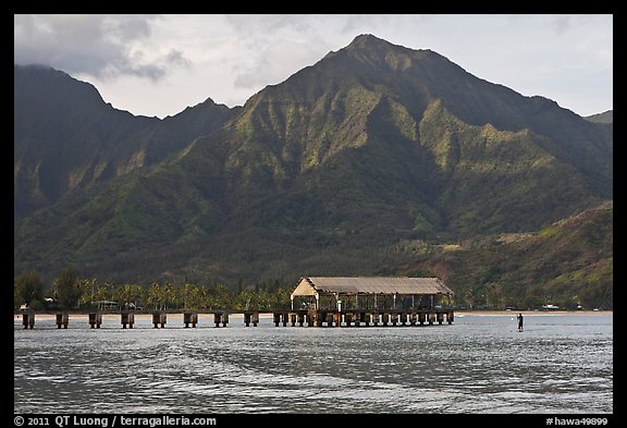 Hanalei Pier, mountains, and surfer. Kauai island, Hawaii, USA