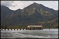 Hanalei Pier, mountains, and surfer. Kauai island, Hawaii, USA