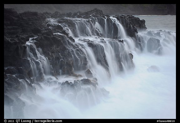 Surf cascading from volcanic shelf. Kauai island, Hawaii, USA