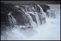 Surf cascading from volcanic shelf. Kauai island, Hawaii, USA