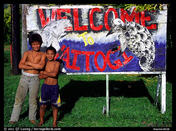 Children in front of a turtle a shark sign in Vaitogi. Tutuila, American Samoa