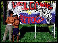 Children in front of a turtle a shark sign in Vaitogi. Tutuila, American Samoa