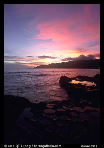Water-filled  grinding stones holes (foaga) and Leone Bay at sunset. Tutuila, American Samoa