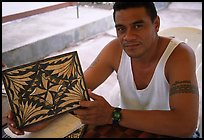 Young man showing an artwork based on traditional siapo designs. Pago Pago, Tutuila, American Samoa