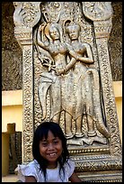Girl and sculpture at Wat Phnom. Phnom Penh, Cambodia (color)